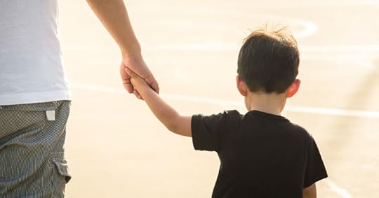 Young boy expressing trust by holding man's hand