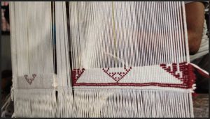 img showing cellular automata weaving in progress with white and red threads