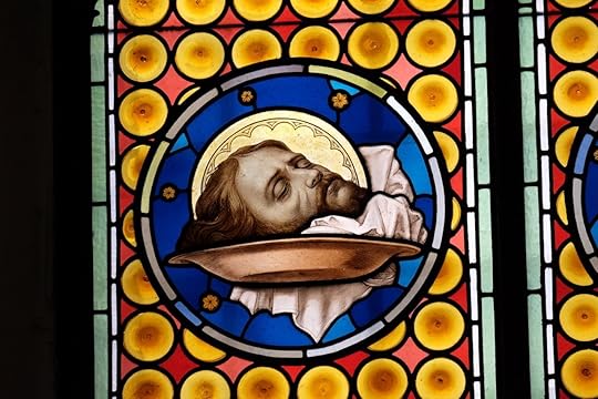 The head of Saint John the Baptist, stained glass window in Basilica of San Silvestro in Capite in Rome, Italy