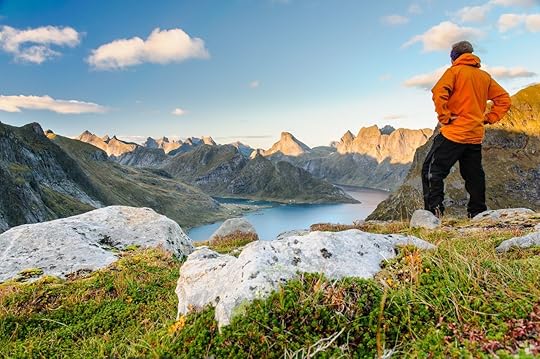 Relaxed hiker enjoys stunning views on fjords and mountain peaks of Lofoten islands, Norway