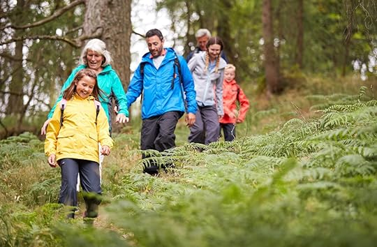 family walking downhill on a trail in a forest