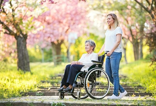 Elderly grandmother in wheelchair with granddaughter in spring nature