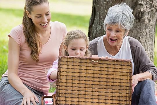 Grandmother mother and daughter with picnic basketball sitting at the park