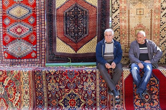 Armenian men sit and relax on carpets at the Vernissage Market in Yerevan, Armenia
