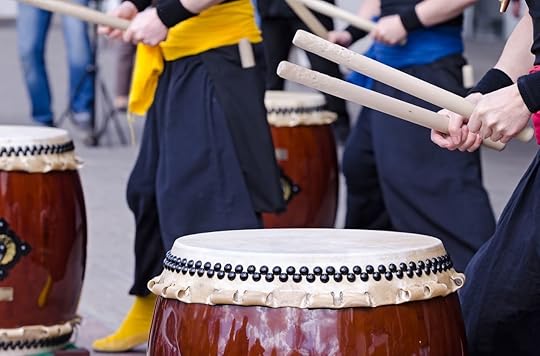 Group of japanese musicians playing on traditional japanese percussion instrument Taiko gold Wadaiko drums