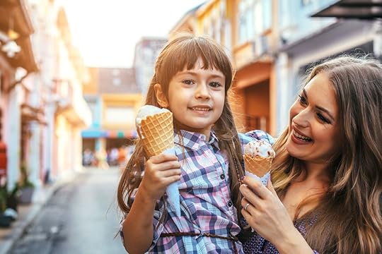 Mom and daughter eating ice cream in front of the outdoor cafe