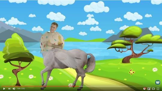 Against a cartoon backdrop of mountains, a lake, trees, and grass, Justin Bieber in his ice cream cone suit is melded with the body of a pegasus.