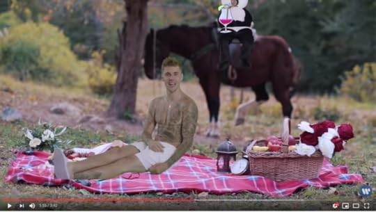 Beebs is sitting shirtless on a picnic blanket with flowers and candles and stuff, while in the background, Sad Panda Ed is greenscreened on the back of a horse, holding a daiquiri. Ed is holding it, I mean. With the video, I really need to clarify that.