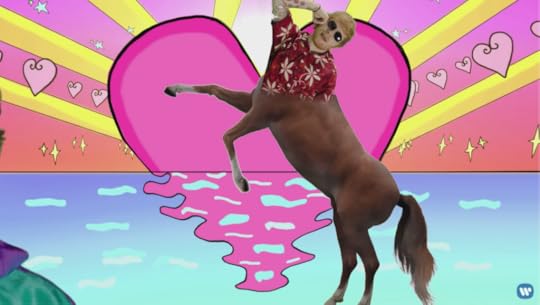 The top half of poolside Ed is green screened over the body of a rearing horse, in front of a giant pink heart setting like the sun into neon blue water.