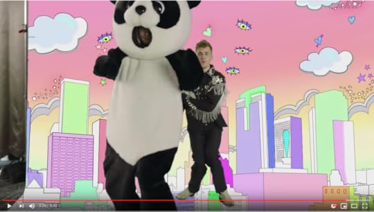 Miserable Panda Ed and Cowboy Beeber are dancing in front of a pink sky background with a pastel city scape as eyes and hearts fly through the sky.