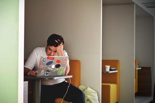 A man is struggling to learn new technology on his laptop computer.