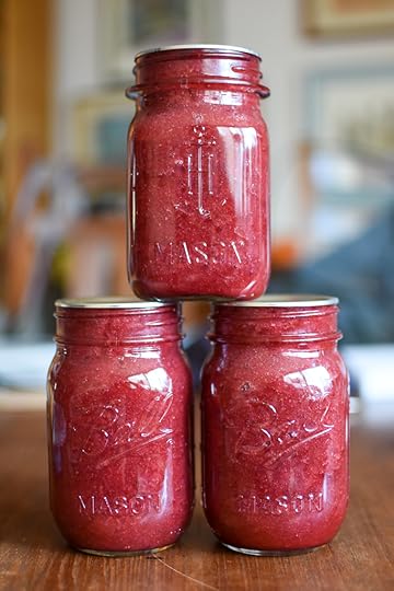 Three pint jars of low sugar strawberry rhubarb jam, stacked into small pyramid.