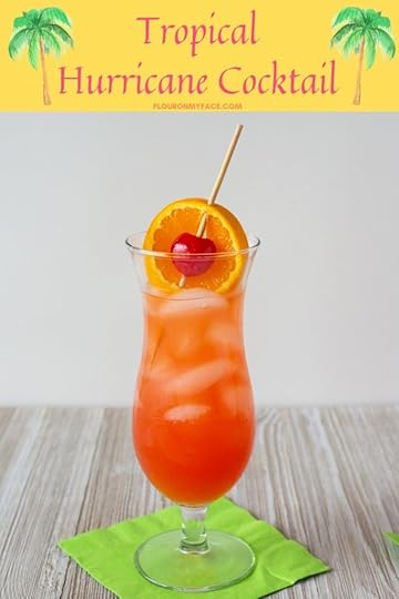 The Classic Hurricane Cocktail served in a tall hurricane glass with a orange slice and maraschino cherry garnish.
