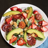 spinach salad with chicken, strawberries, and other fruit