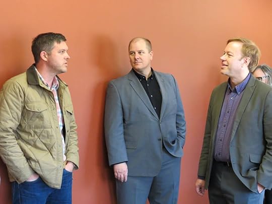 Image may contain: 3 people, people standing and suit