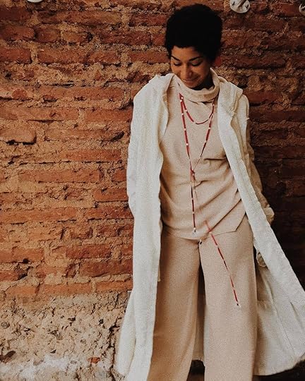 Tenida de beatle y pantalón beige con abrigo blanco y collar rojo de Mercado Moderno Valparaíso