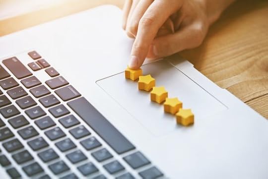 hand gives five stars rating as product feedback with laptop