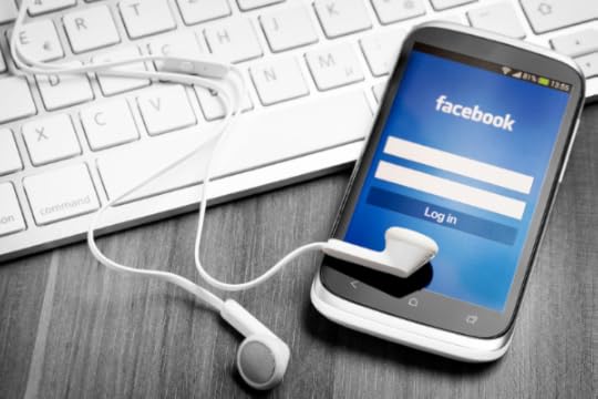 keyboard with mobile phone showing Facebook login screen