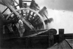 Deckhand standing next to the sternwheel in motion