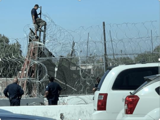 A man straddles a fence, as described in the text of the story.