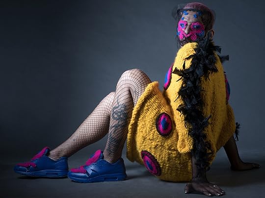 trabajo de alumna Paloma Tapia en Taller Vertical en Textil e Indumentaria UDP chaleco largo lana amarillo con plumas negras en brazos y círculos fucsia y azul