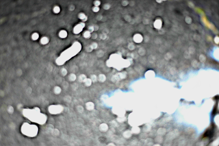 a blurry and over exposed picture of shards of glass on the ground