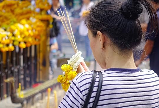A young woman praying at Erawan Temple in Bangkok, Thailand