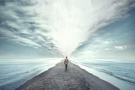 man walking on narrow beach with water on either side