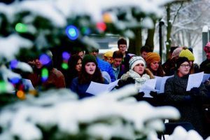 Framed by the branches of a Christmas tree Saturday, carolers sing at Friendship Square in Moscow. Kai Eiselein/Daily News
