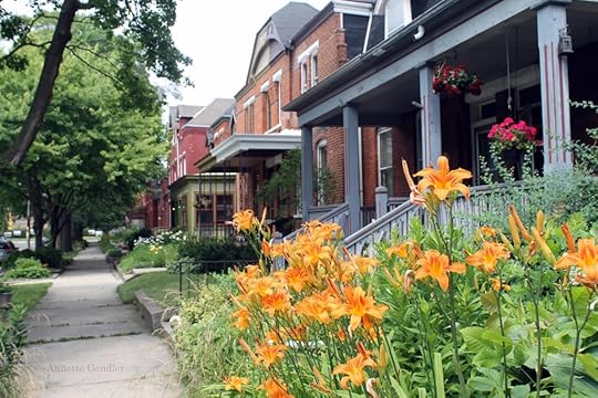 row of red brick two-stories homes with lush front yards in Pullman Historic District, Chicago, tiger lilies in the foreground