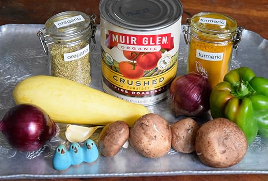 can of fire-roasted tomatoes, jars of oregano and turmeric, yellow squash, mushrooms, red onions, garlic