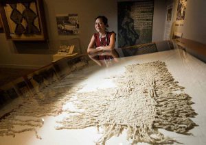Senior curator Tessa Campbell with a rare example of a blanket made from woolly dog hair and mountain goat hair at the Hibulb Cultural Center in Tulalip (Washington, USA). The blanket is part of the current exhibit