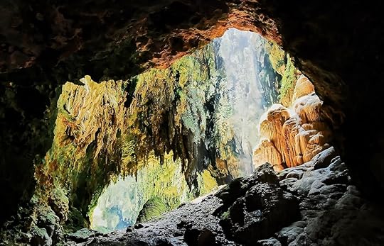 View into one chamber of the limestone Callao Cave with sunlight entering from the rooftop