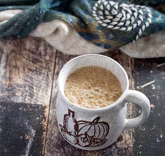 Slow Cooker vegan maple pumpkin latte in a ceramic mug with pumpkins and squash on it