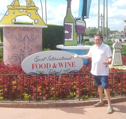 Howard standing in front of the Epcot International Food & Wine sign in Disney World, Florida<br />