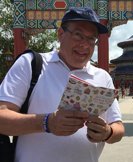 Howard holding the Festival Passport for the Epcot International Food & Wine Festival.