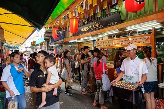 Person stands for Buddha's Hand herbal salts Thailand near Sushi Shop at Wang Lang Market