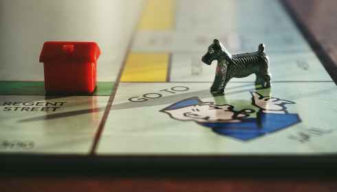 dog and house toy on monopoly board game