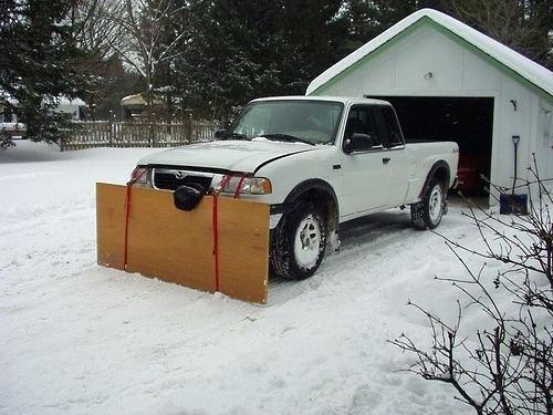a snow plow mounted on truck clears homemade stuff in