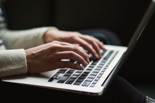 woman's hands typing on laptop