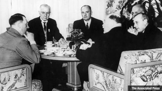 Picture of men around a table. Hitler and Thomas J Watson are in the picture seated together.