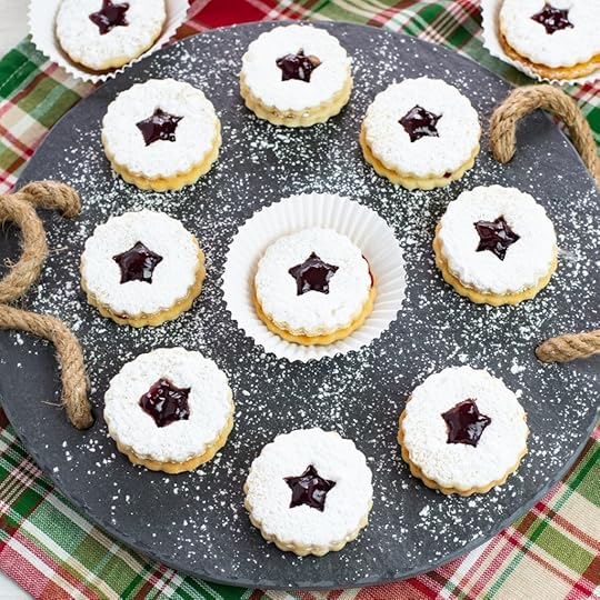 Raspberry Linzer Sandwich Cookies on a slate serving platter