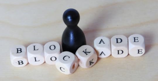 Game piece breaking through blocks that spell blockade as a symbol of overcoming obstacles