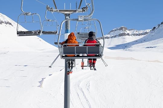 Two skiers go up on chair-lift