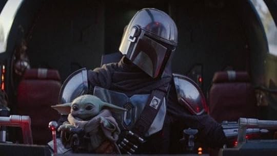 Baby Yoda sits in Mando's lap in 'The Mandalorian' while they ride in a spacecraft.