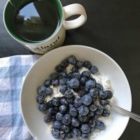 cup of tea with bowl of berries and yogurt