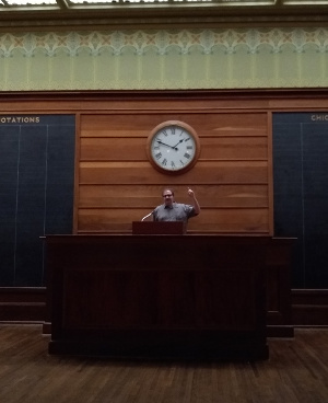 Leonard standing at a podium on the floor of the Chicago Stock Exchange.
