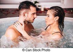 Young attractive couple relax in hot tub in spa center.