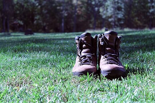 A pair of brown hiking boots sitting in green grass