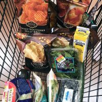 bags of chips with other groceries in cart
